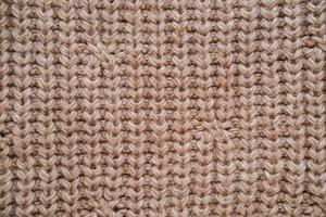 Close-up of the texture of knitted woolen fabric in light brown color photo