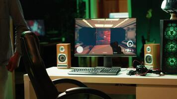 Professional gamer with headset on competing in online multiplayer videogame, streaming live from apartment. Streamer playing on PC, using headphones to talk with audience, camera A video