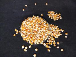 Pile of dry corn kernels. Stacked corn kernels isolated on black background. photo