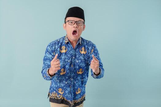 Stressful Indonesian government worker man wearing blue batik uniform going crazy. photo
