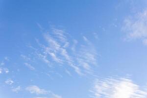 blue sky background with sparse cirrus clouds and moon photo