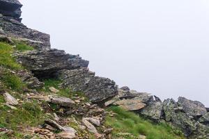 mountain landscape, rocks on a mountainside in thick fog photo