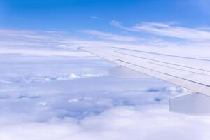 view from airplane window during flight, wing and cloudscape, view above clouds photo