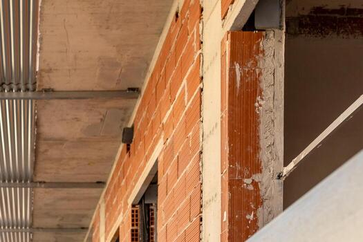 Angled view inside a construction site showing exposed brickwork, concrete slabs, capturing the raw elements of building under development. photo