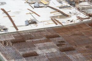 Construction workers install formwork and iron rebars or reinforcing bar for reinforced concrete partitions at the construction site of a large residential building. photo