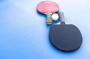 two ping-pong rackets and a ball on a green table. Close-up, ping-pong net. photo