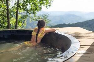 little girl in a hot tub in the mountains, summer photo