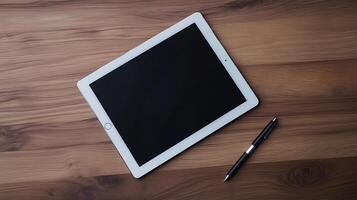 A sleek tablet rests on a wooden surface beside a stylish pen photo
