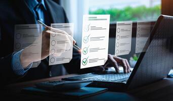 Business performance checklist, businessman using laptop doing online checklist survey, Check marks on checklist and Filling online form or answering questions. evaluation, online survey, online exam photo