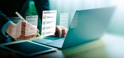 Business performance checklist, businessman using laptop doing online checklist survey, Check marks on checklist and Filling online form or answering questions. evaluation, online survey, online exam photo