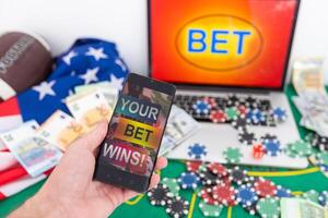 hands of a man holding a online betting device. All screen graphics are made up. photo