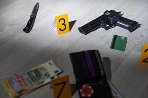 High contrast image of a crime scene with gun and markers on the floor photo