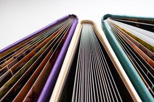 Books. A lot of books with bright covers in one pile isolated on white background. Design element, paper and leather texture. Colorful books on the shelf, close up photo