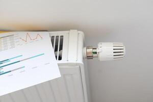 gas bill in front of heating radiator. Payment for heating in winter. photo