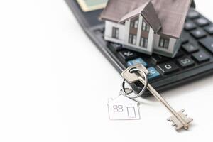 House key with house model keychain on house layout plan photo