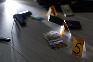 Crime scene investigation concept - Pistol and bullet shell against the yellow crime marker on apartment floor photo