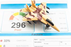 Credit Report text on paper sheet with magnifying glass on chart, dice, spectacles, pen, laptop and blue and yellow push pin on wooden table - business, banking, finance and investment concept photo
