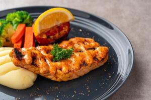 Grilled salmon fillets with mentai sauce and mash potato plating on black plate with negative space for text. photo