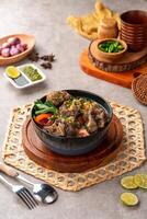 sop buntut or oxtail soup. Made from pieces of beef tail that are seasoned then put in a slightly beef broth with sliced potatoes, carrots, tomatoes, celery. Indonesian traditional culinary photo
