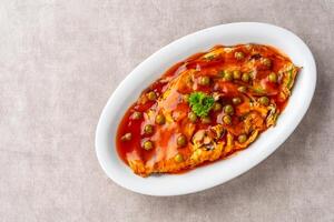 Fu yung hai, Puyonghai or egg foo young, a famous Chinese-style emelette dish in Indonesia. made from egg, vegetables and sauce photo