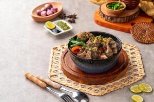 sop buntut or oxtail soup. Made from pieces of beef tail that are seasoned then put in a slightly beef broth with sliced potatoes, carrots, tomatoes, celery. Indonesian traditional culinary photo