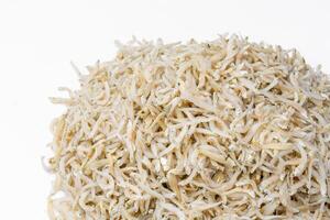 Fresh dried anchovies on White Background. Raw dry salted sea fish. saltwaterforage fish. Ikan asin teri medan. photo