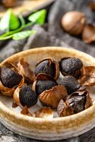 Fermented black garlic. The color is a result of the Maillard reaction or caramelization. Black garlic can help to regulate blood sugar levels photo