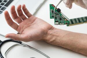 High angle of anonymous medical practitioner in gloves using modern tool to implant blue RFID microchip into hand of patient over table with futuristic scanner in laboratory photo