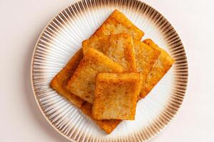 Turnip cake or Chai tow kway. Turnip cake is a common dish or dim sum of Teochew cuisine in Chaoshan, China usually cut into rectangular slices and sometimes pan fried before serving photo