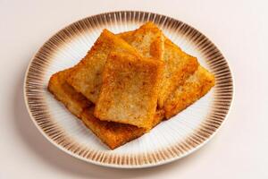 Turnip cake or Chai tow kway. Turnip cake is a common dish or dim sum of Teochew cuisine in Chaoshan, China usually cut into rectangular slices and sometimes pan fried before serving photo