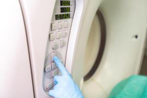 hand of doctor operating Computed Tomography device. photo