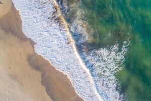 shore of a beach at sunrise, overhead view with drone photo