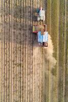 Directly above drone view. Potato Harvester with a tractor. Seasonal harvesting of potatoes. photo