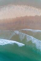 aerial shot of a beach with nice sand and green turquoise water. Top view of a beach scene with a drone. Summer concept background photo