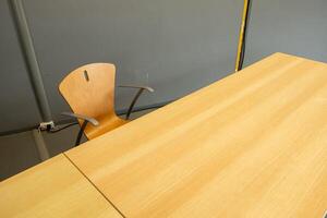 an empty light wood chair and table in a classromm photo
