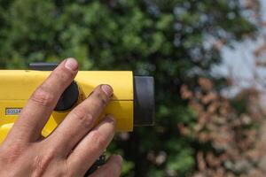 hand of a man using a theodolite, surveyor equipment tacheometer. Topography works photo