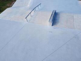 Aerial view with drone of a skatepark near the sea. Sloped metal rails for grind tricks photo