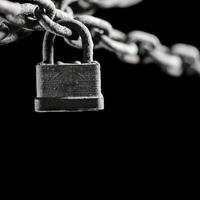 Worn rusted chain and pad lock on black background. Conceptual strength, protection, or security system. photo