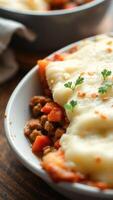 Close-up of Creamy Mashed Potatoes with Meat and Vegetables in a White Bowl photo