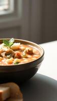 Close-up of a bowl of soup with bread in the background photo