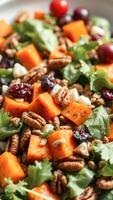 Closeup of a salad with roasted sweet potatoes, pecans and cranberries photo