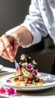 Chef Carefully Arranging Edible Flowers on a Dish photo