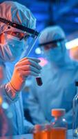 Scientist in Lab Holding a Test Tube with Red Liquid photo