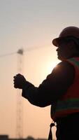 Silhouette of a construction worker at sunset photo