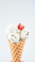 Closeup of Vanilla Ice Cream Cone with Strawberry Topping photo