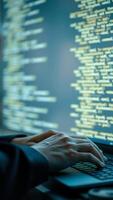 Close Up of Hands Typing on Laptop Keyboard with Blurred Code on Screen photo