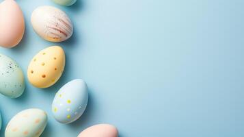 Top view flat lay photo of easter decorations painted pastel eggs, spring blossom on blue background with copy space.