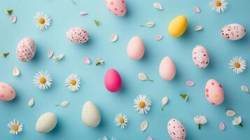 Top view flat lay photo of easter decorations painted pastel eggs, spring blossom on blue background with copy space.