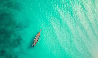 Boat on the water surface from top view, turquoise blue water background from top view, summer seascape from air, island, travel and vacation image photo