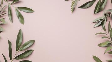 Green leaves are creating a frame on a pink background with copy space in the center photo